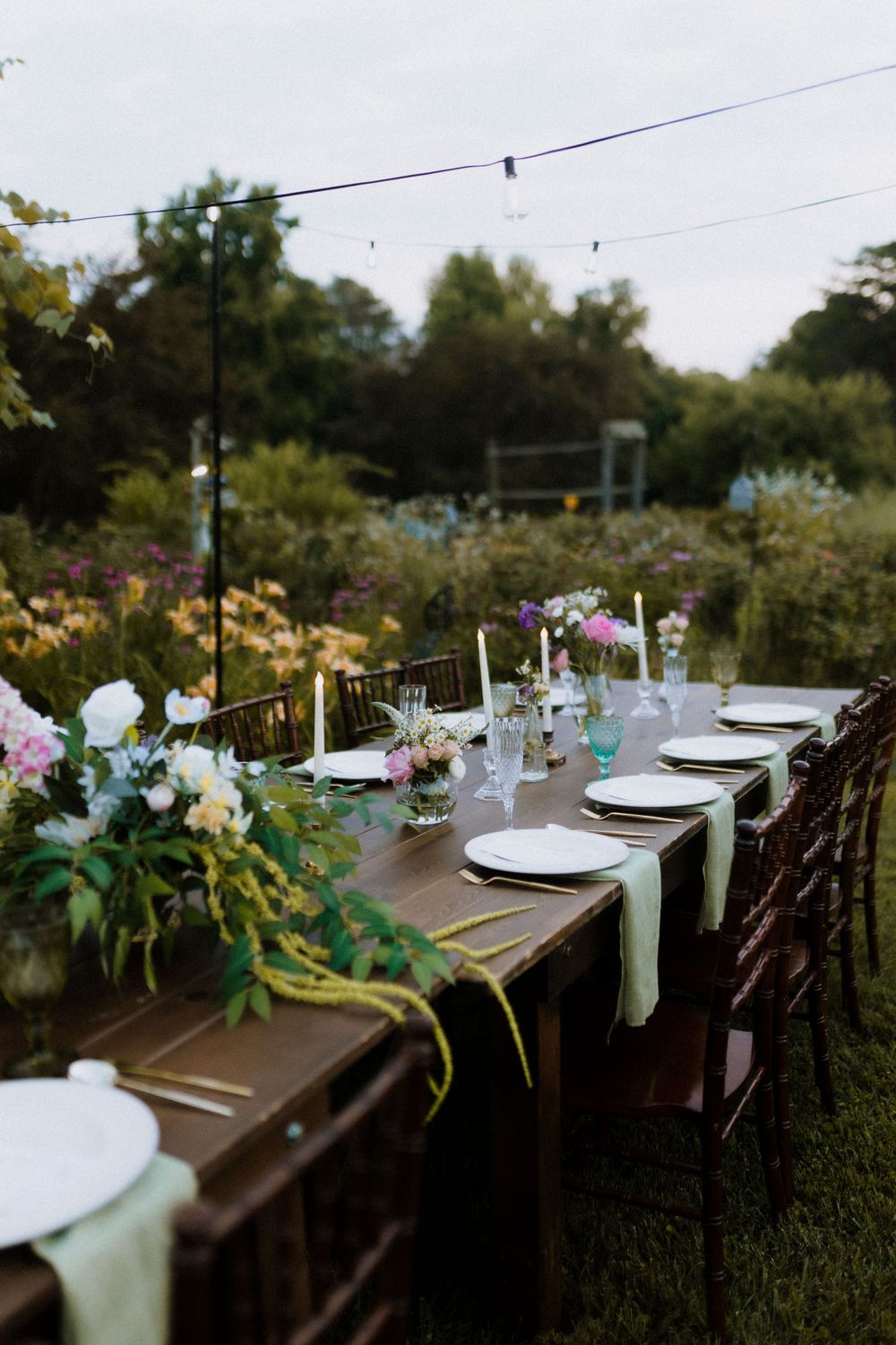 An elegant outdoor wedding table setting with floral arrangements and place settings.