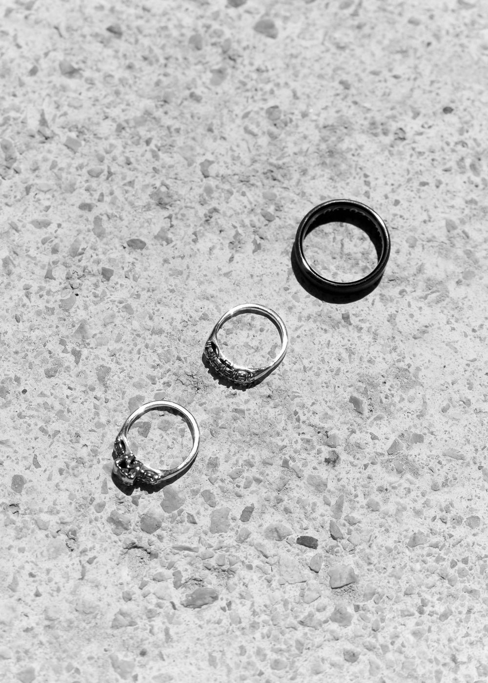 Eight black and white photographs arranged in sequence show dramatic motion blur of flying rings across textured concrete.