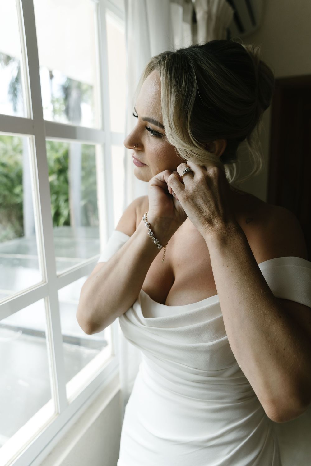 A contemplative figure in a white tank top gazes through a sunlit window in a sequence of artistic photos.