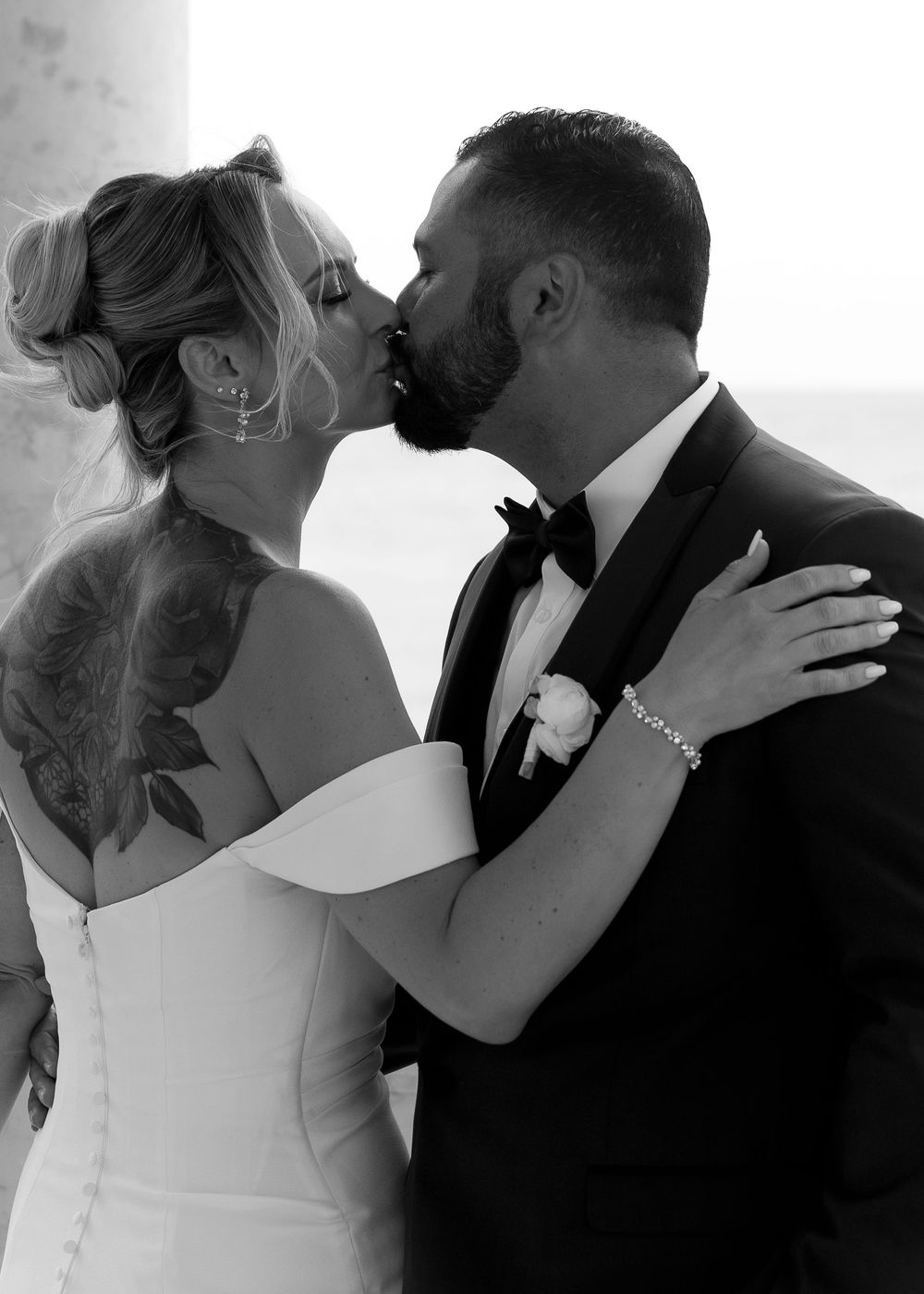 A series of black and white wedding photos showing a couple sharing romantic kisses after their ceremony.