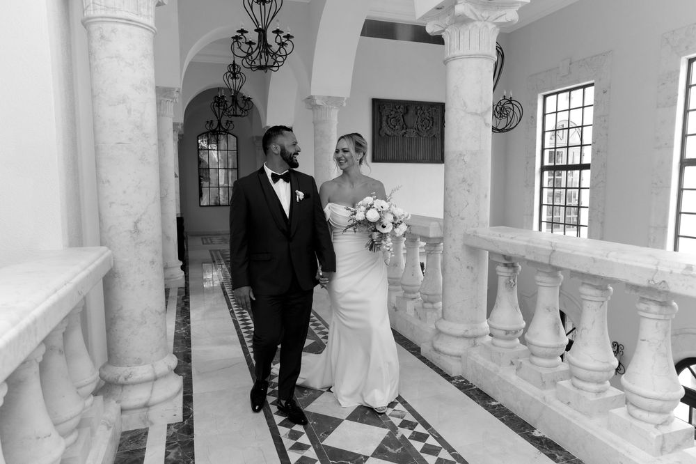 Black and white wedding photos show elegantly arranged marble columns in a historic venue with natural lighting.