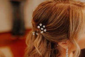 Close-up of a bride's elegant half-up hairstyle adorned with delicate pearl flower hair pins.