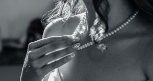 Artistic black and white photo showing jewelry and soft lighting at a wedding.