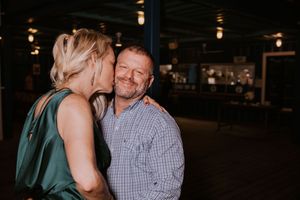 Couple shares intimate moment in dimly lit indoor setting.