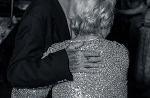 Wedding reception guests dancing together in formal attire.