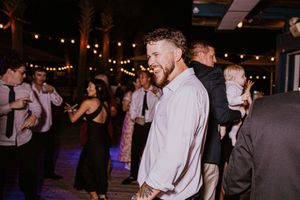 Evening wedding reception with guests dancing under string lights.