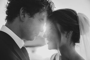 Black and white wedding photo of bride and groom touching foreheads, sharing an intimate romantic moment.