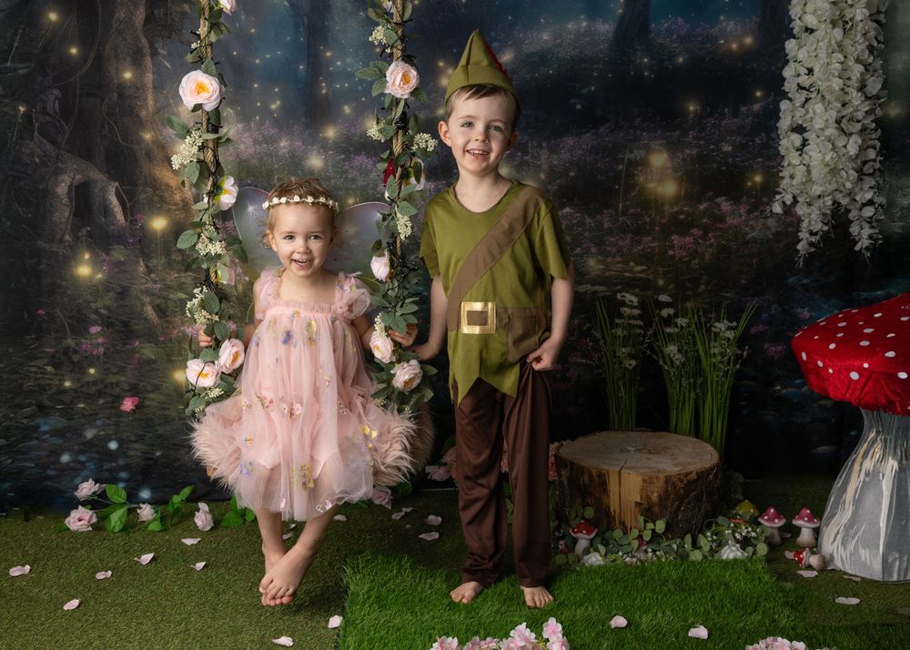 Magical woodland photoshoot with pink fairy dress and green costume against starlit backdrop.