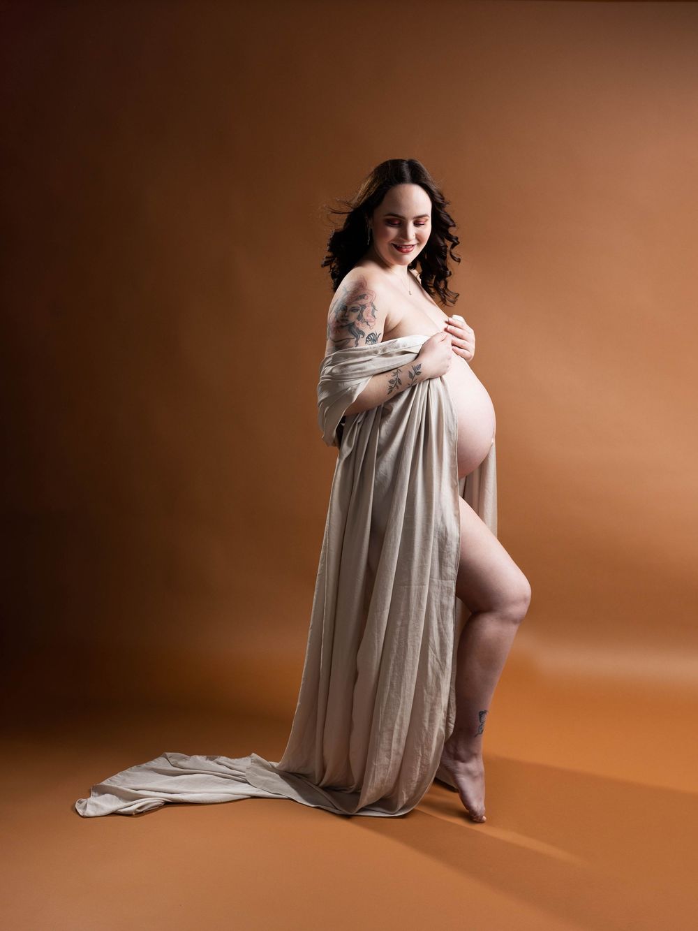A series of artistic maternity portraits showing a pregnant woman in flowing white fabric against a warm brown backdrop.