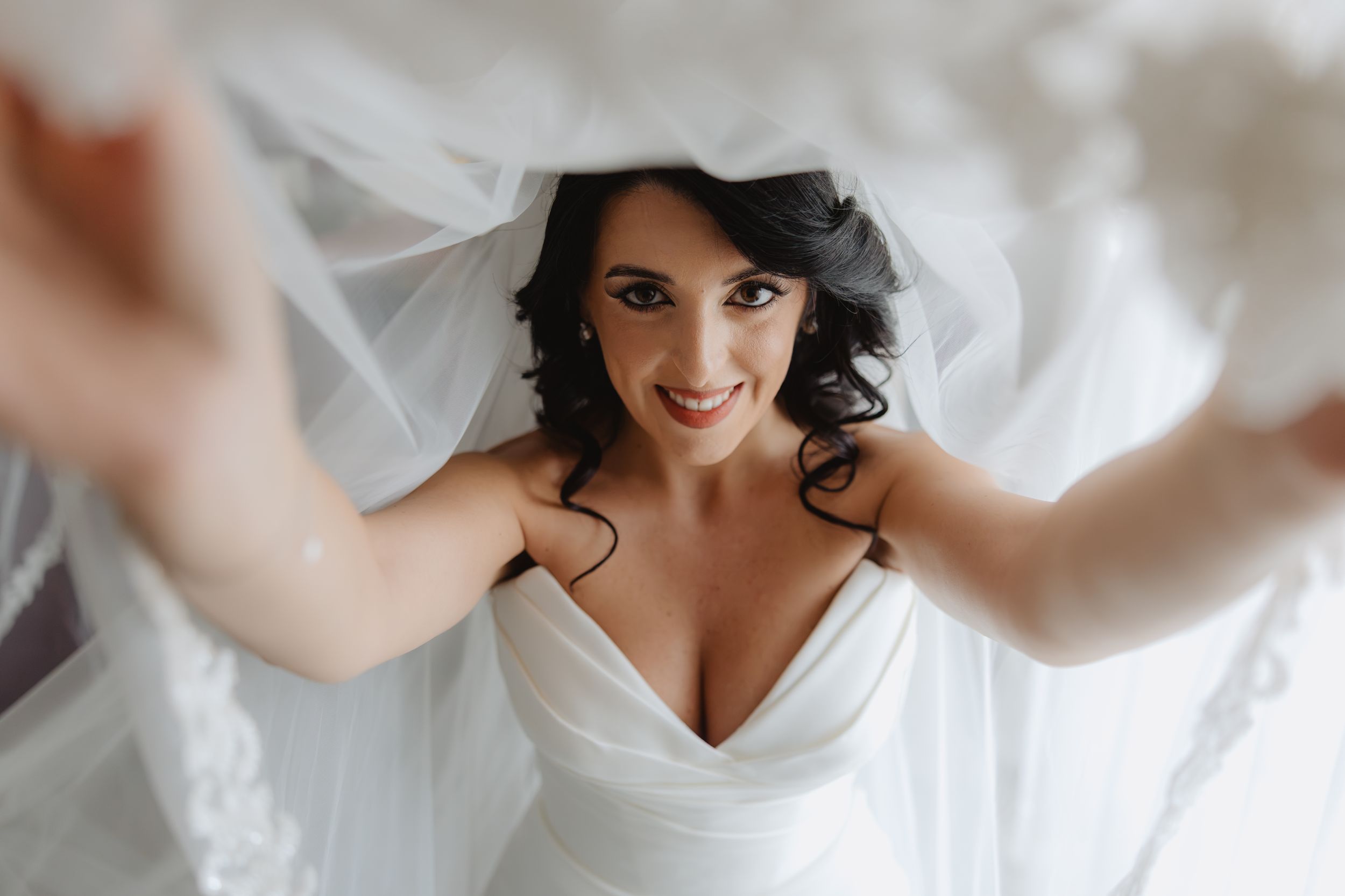 Elena sorride sollevando il velo durante i preparativi del matrimonio, settembre 2026.