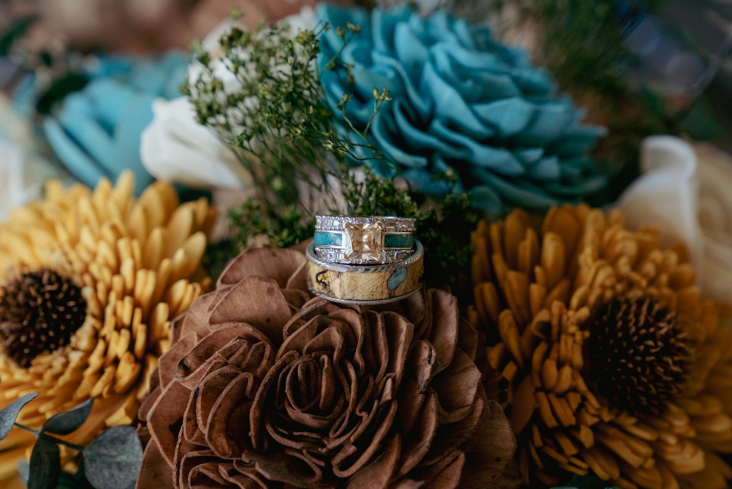 Unique wedding bands on a natural bouquet—yellow diamond, turquoise, and wood-inspired details, perfect for a nature-inspired Oregon wedding