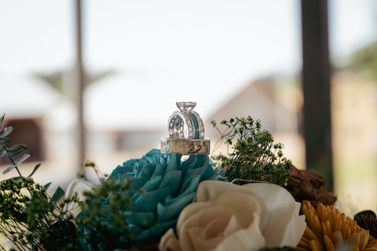 Wedding rings on floral bouquet, romantic indoor Oregon ceremony.