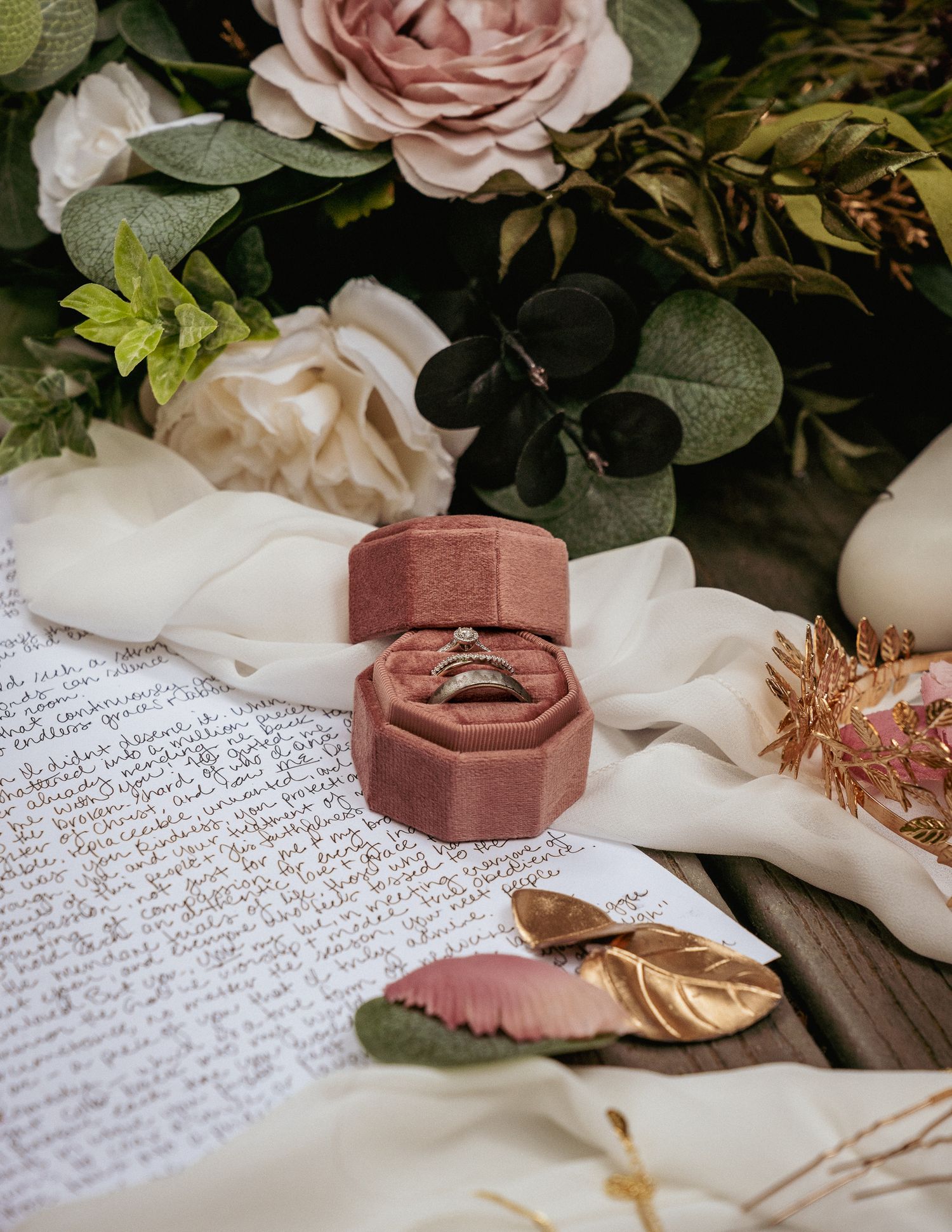 Flat lay of wedding rings, vow letters, and florals—romantic wedding detail inspiration for storytelling photography.