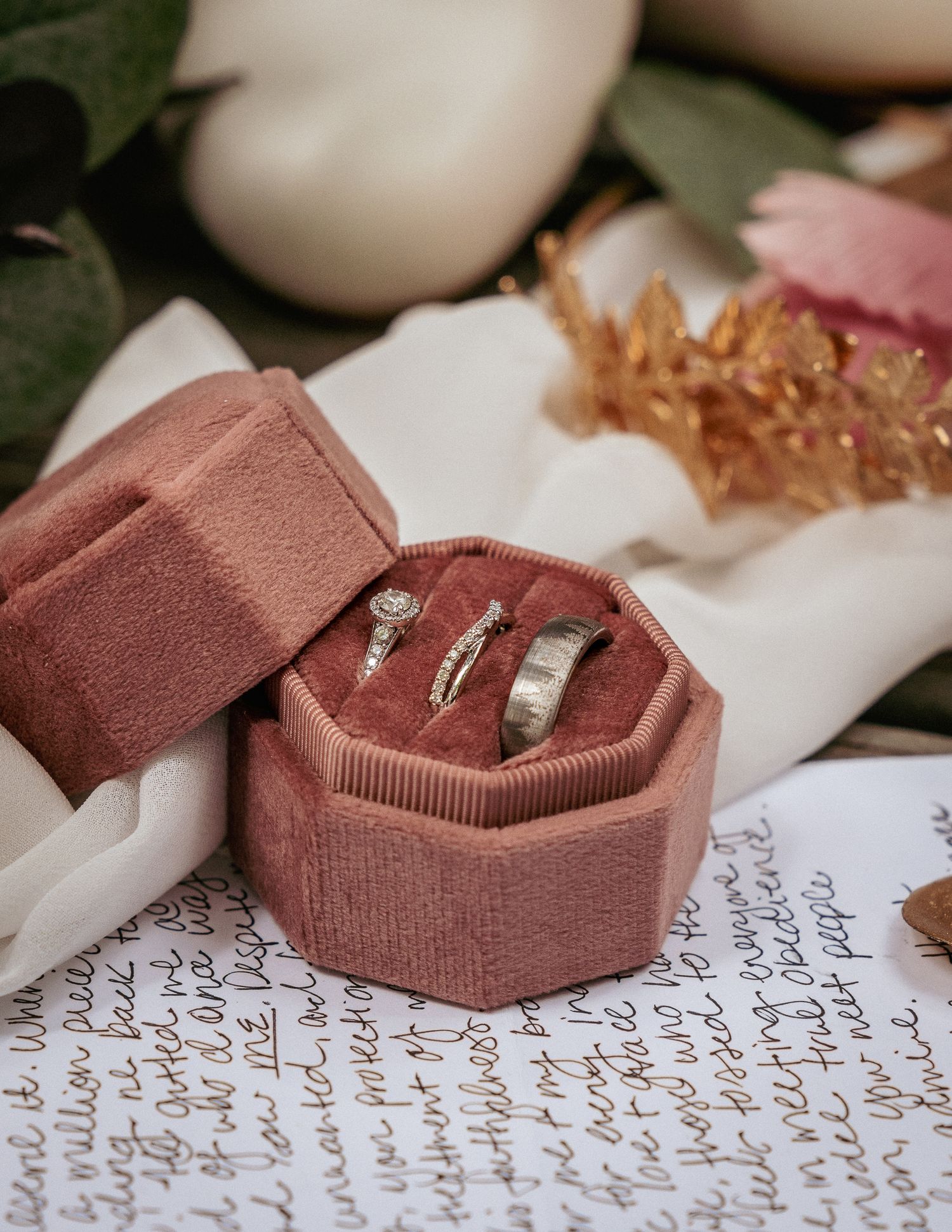 Velvet ring box on vows with gold flakes, luxe elopement detail flat lay.