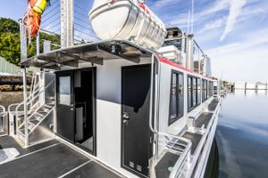 Sleek modern ferry exterior with white and red design against blue sky.