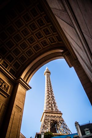 Looking up at the Eiffel Tower replica through an architectural archway in Las Vegas.
