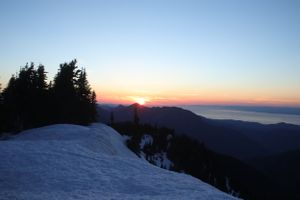 Panoramic winter mountain vista with dramatic sunset lighting.