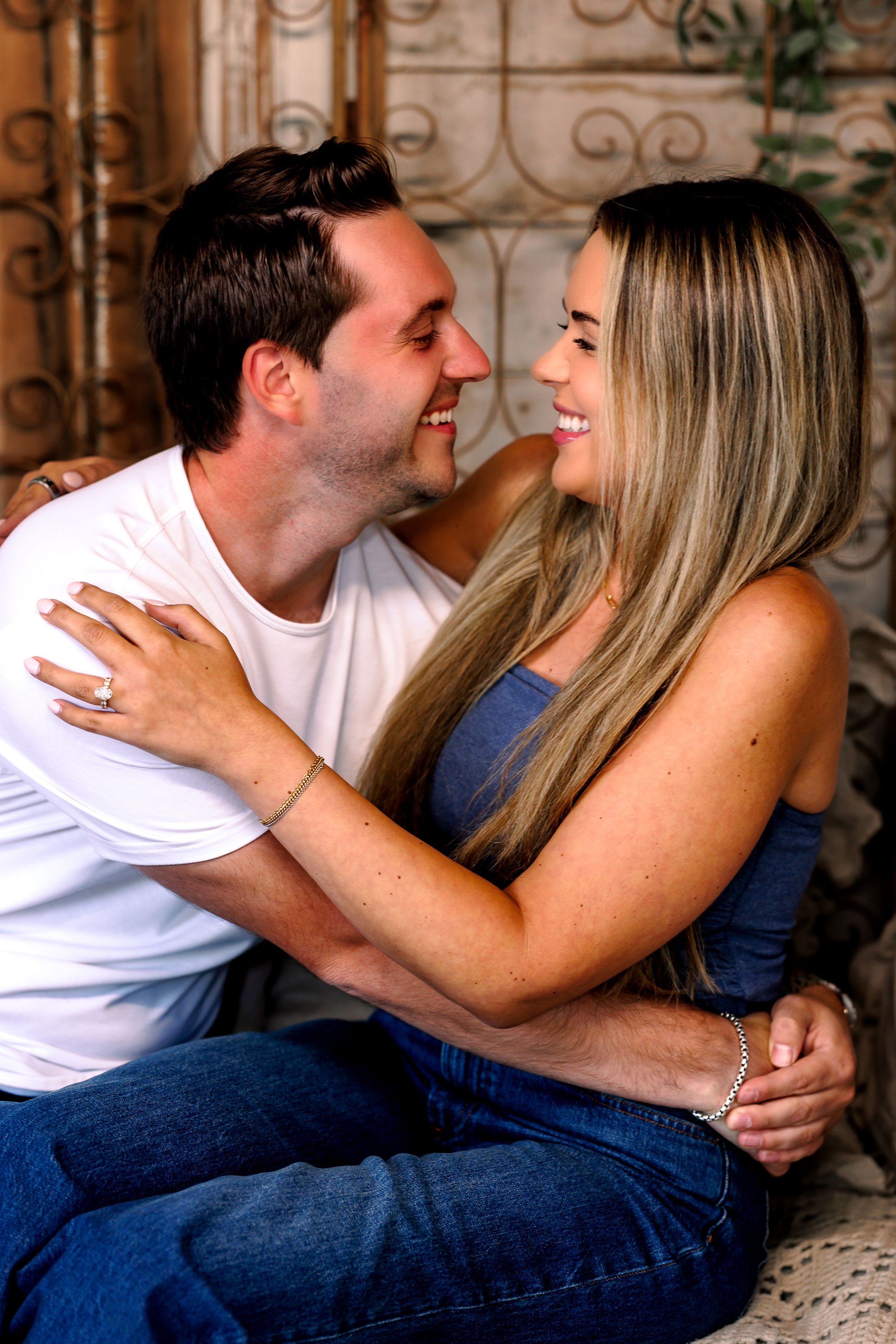 Romantic couple poses intimately on stone steps during engagement photoshoot.