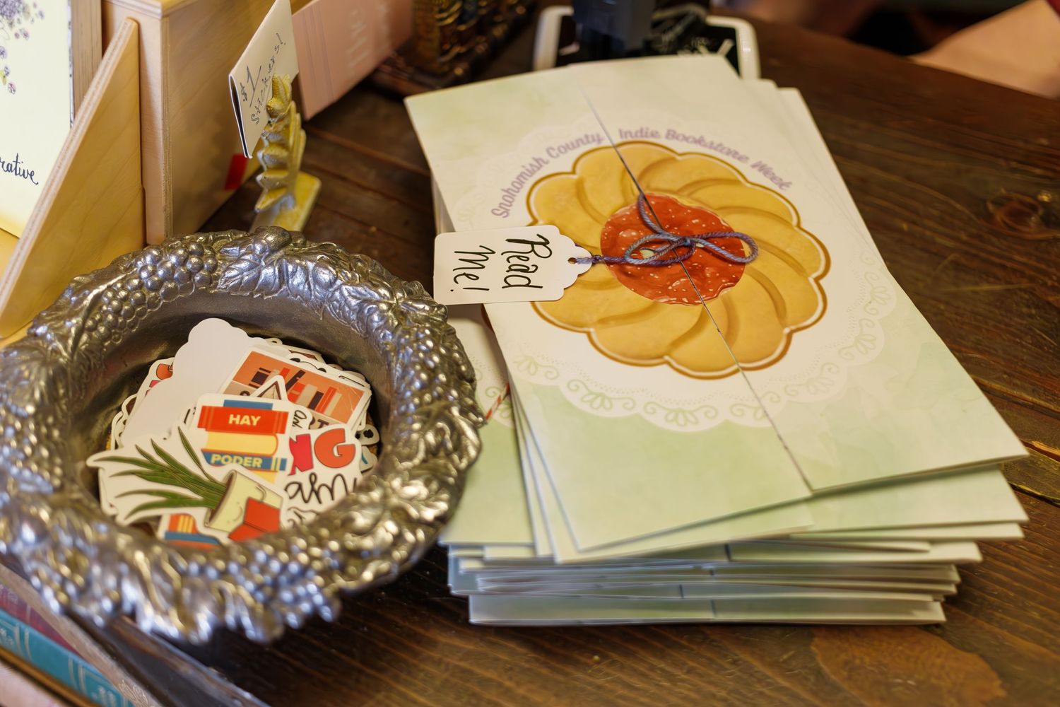 Decorative floral greeting cards and silver dish displayed on wooden table.