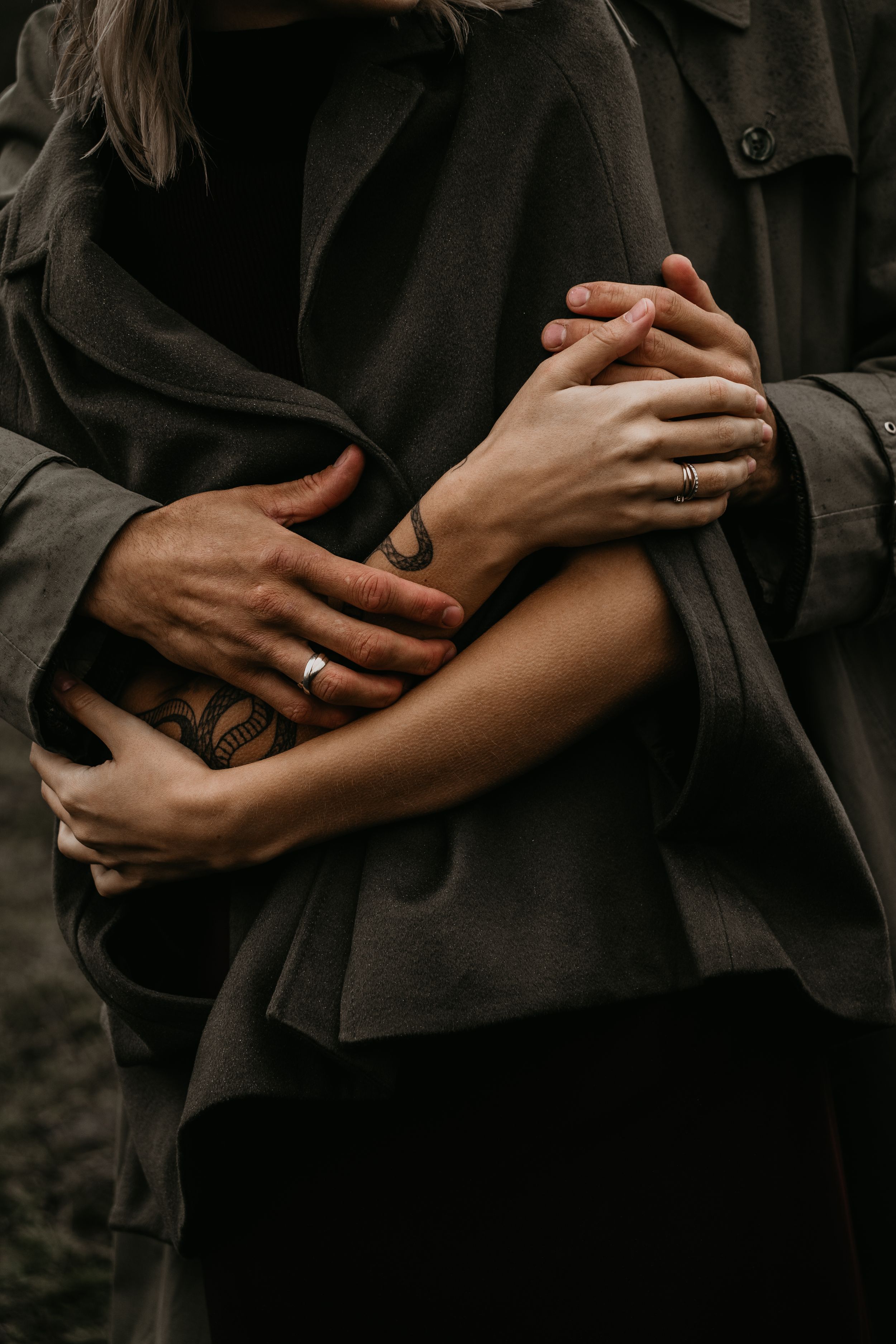 Close-up of two people's hands hugging, showing visible goosebumps