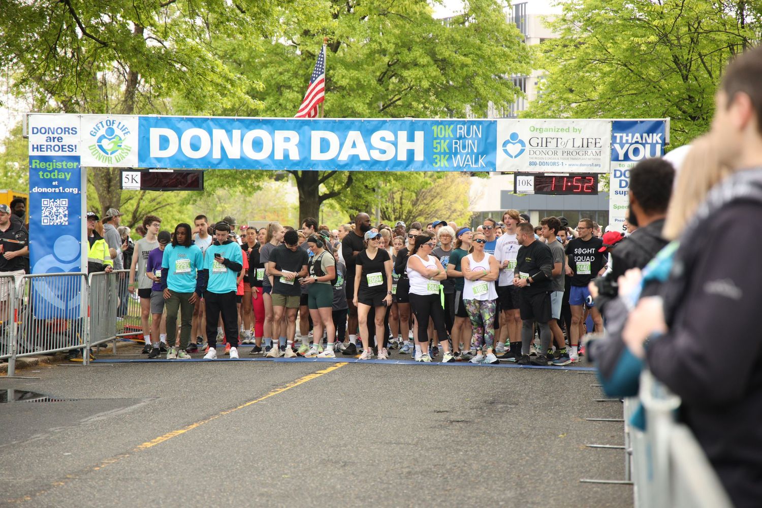 Runners gather at the starting line under a Donor Dash banner at a charity race event.