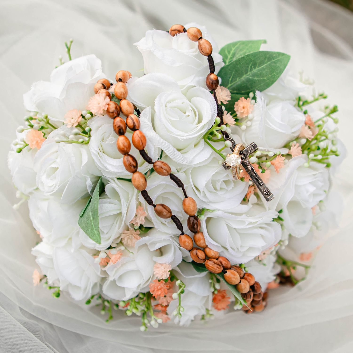Wedding bouquet featuring white roses and peach berries with delicate greenery.