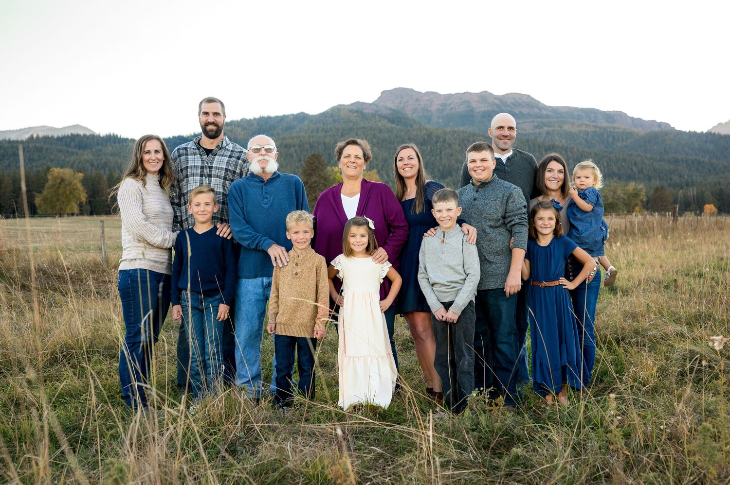 Large family group portrait in casual attire against mountain landscape at dusk. Family Enterprise, Oregon
