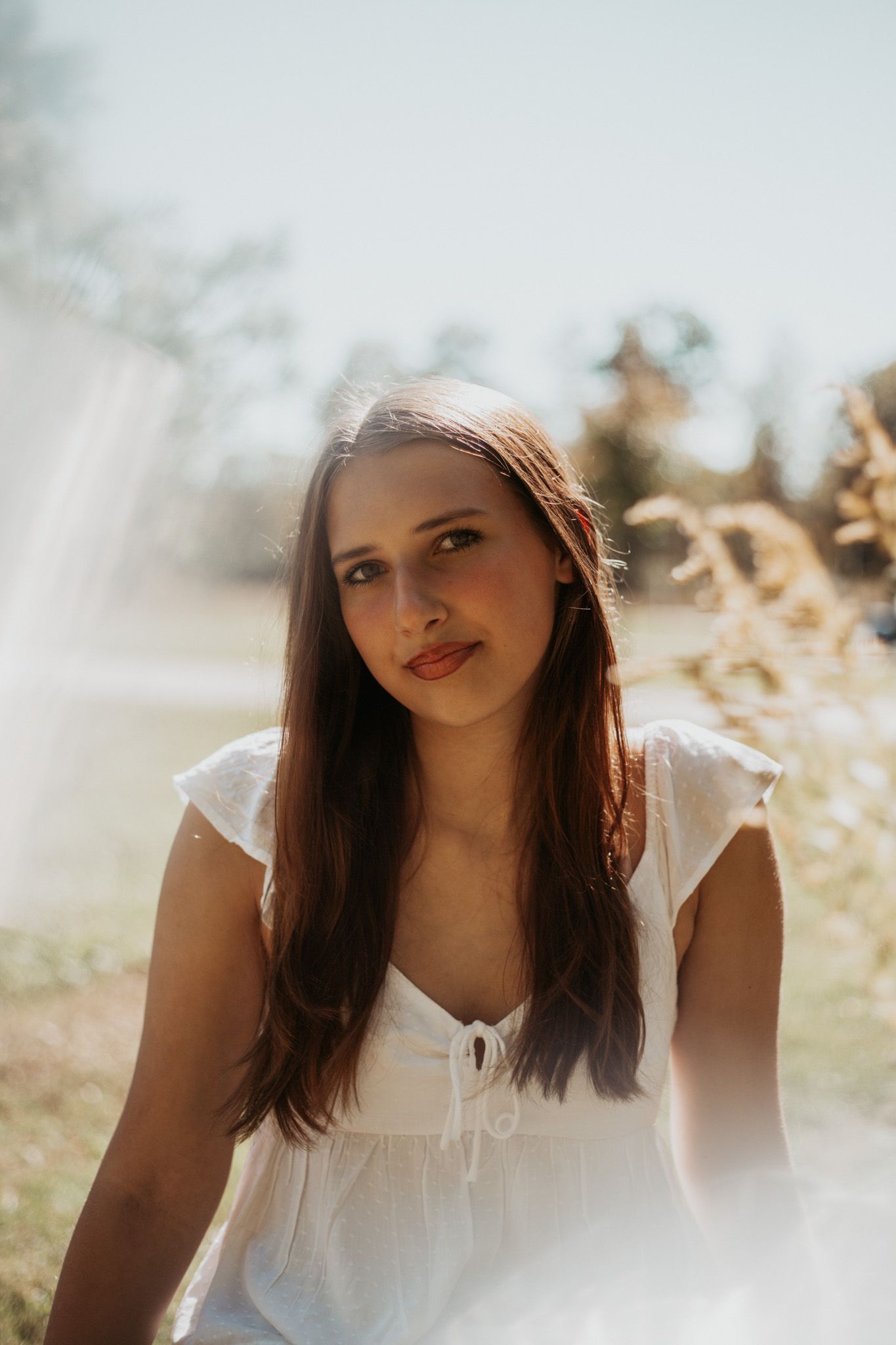 Sun-lit portrait in white summer dress with natural outdoor lighting.