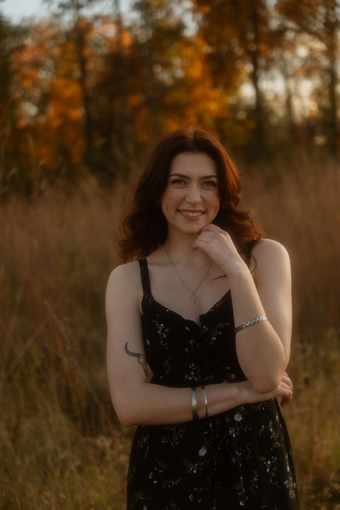 A dreamy autumn field scene with warm golden light filtering through trees at sunset.