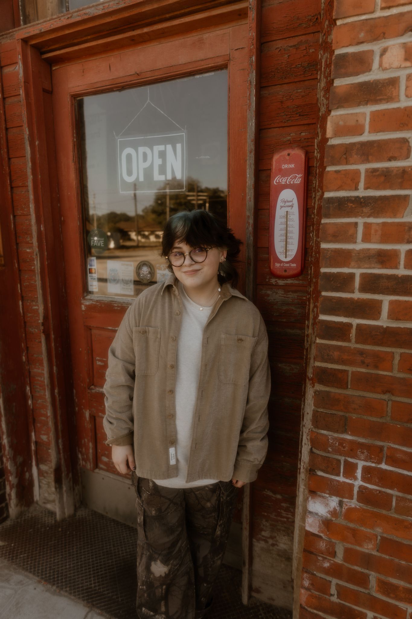 A brick storefront exterior with an 'Open' sign visible in the window.