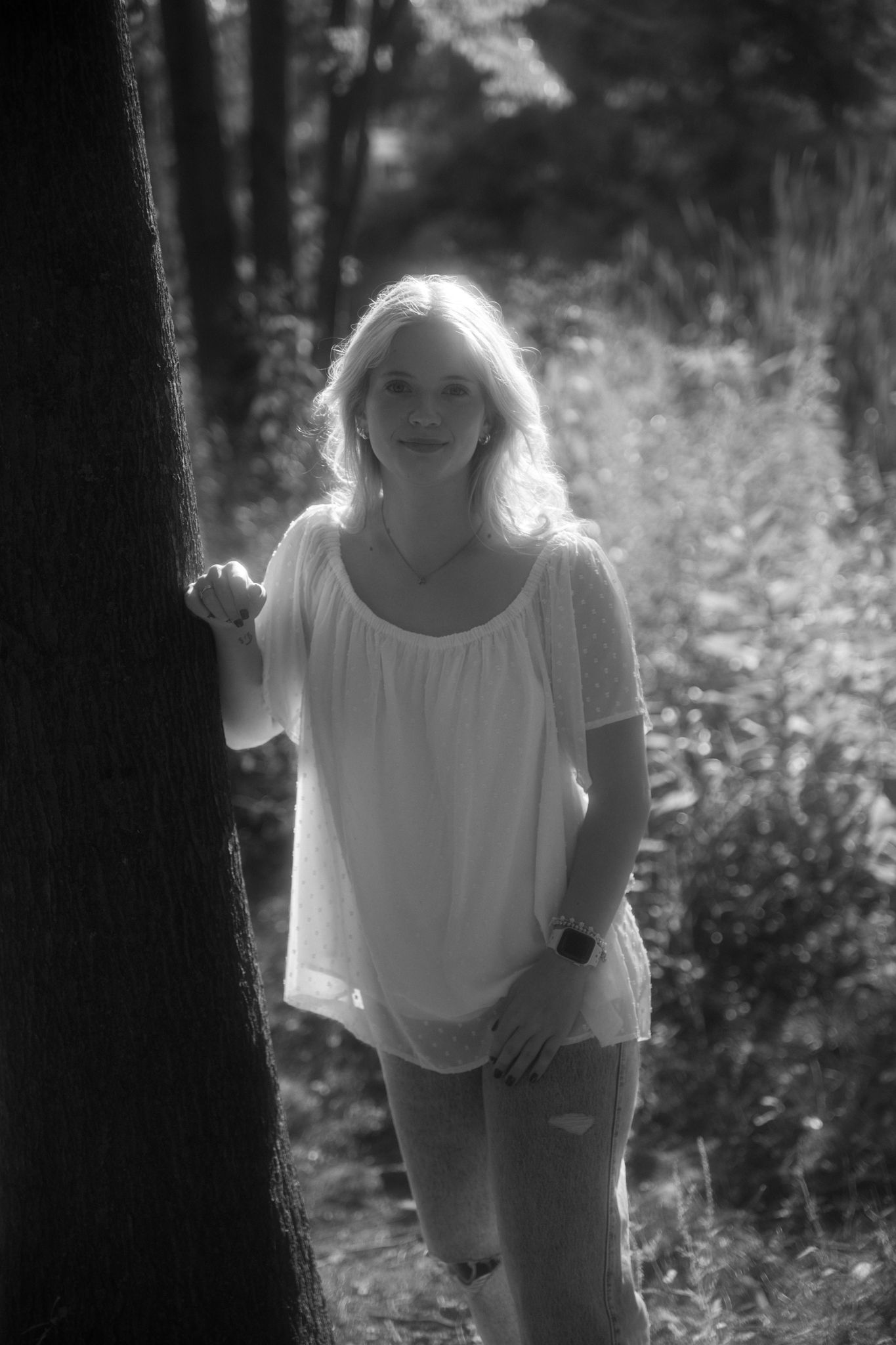 Natural light portrait among trees with dreamy black and white filter.