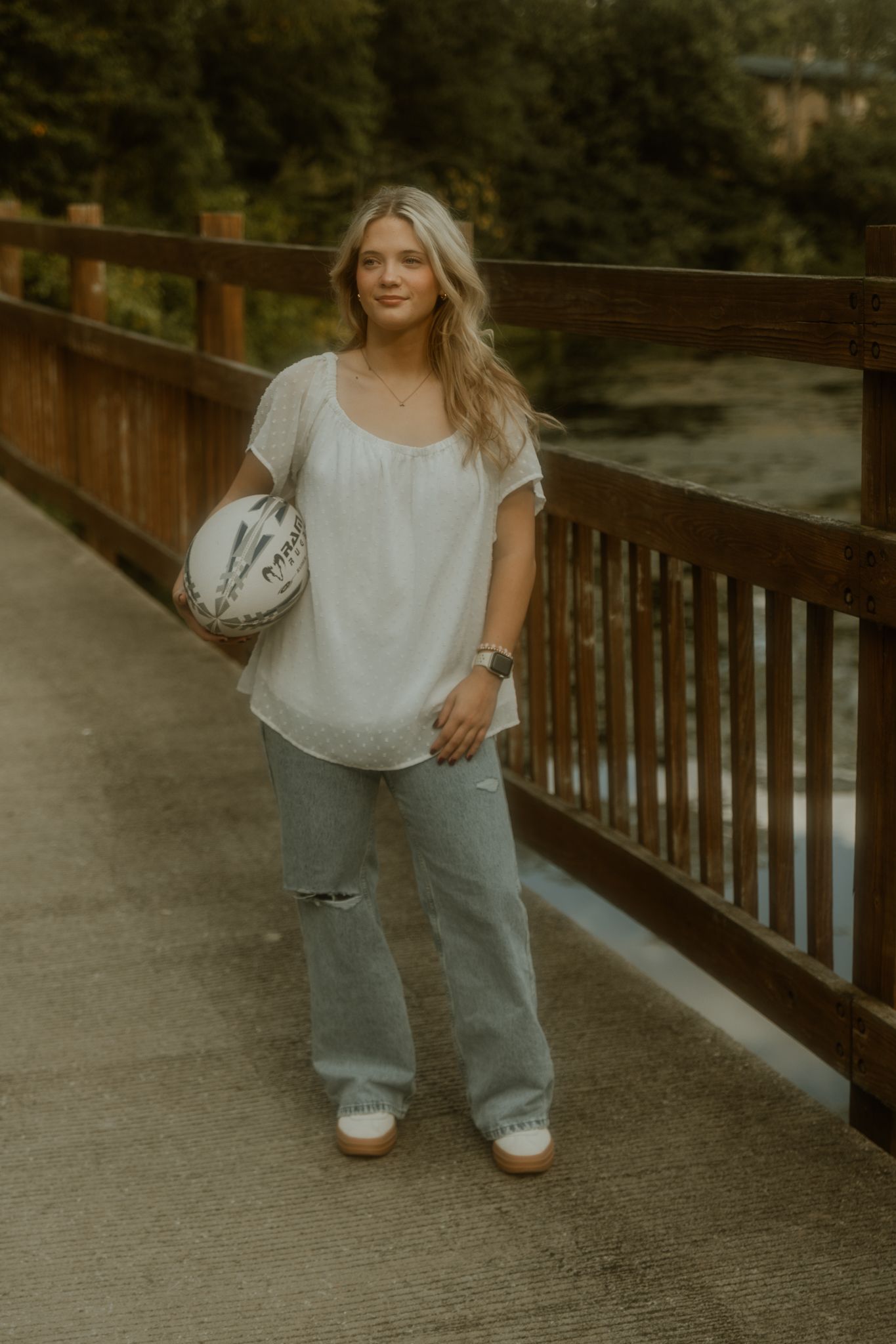 Casual portrait session on wooden bridge with muted vintage tones.