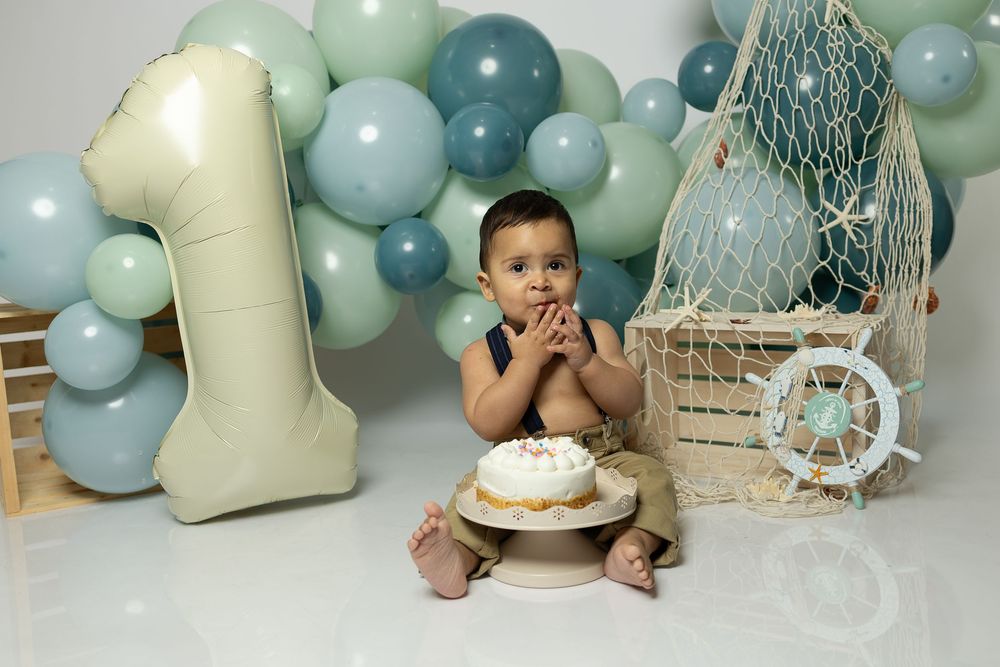 Pastel blue and mint green balloon arch with decorative elements for a baby shower celebration.