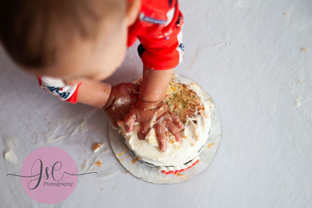 Close-up of messy cake smash session with white frosting.