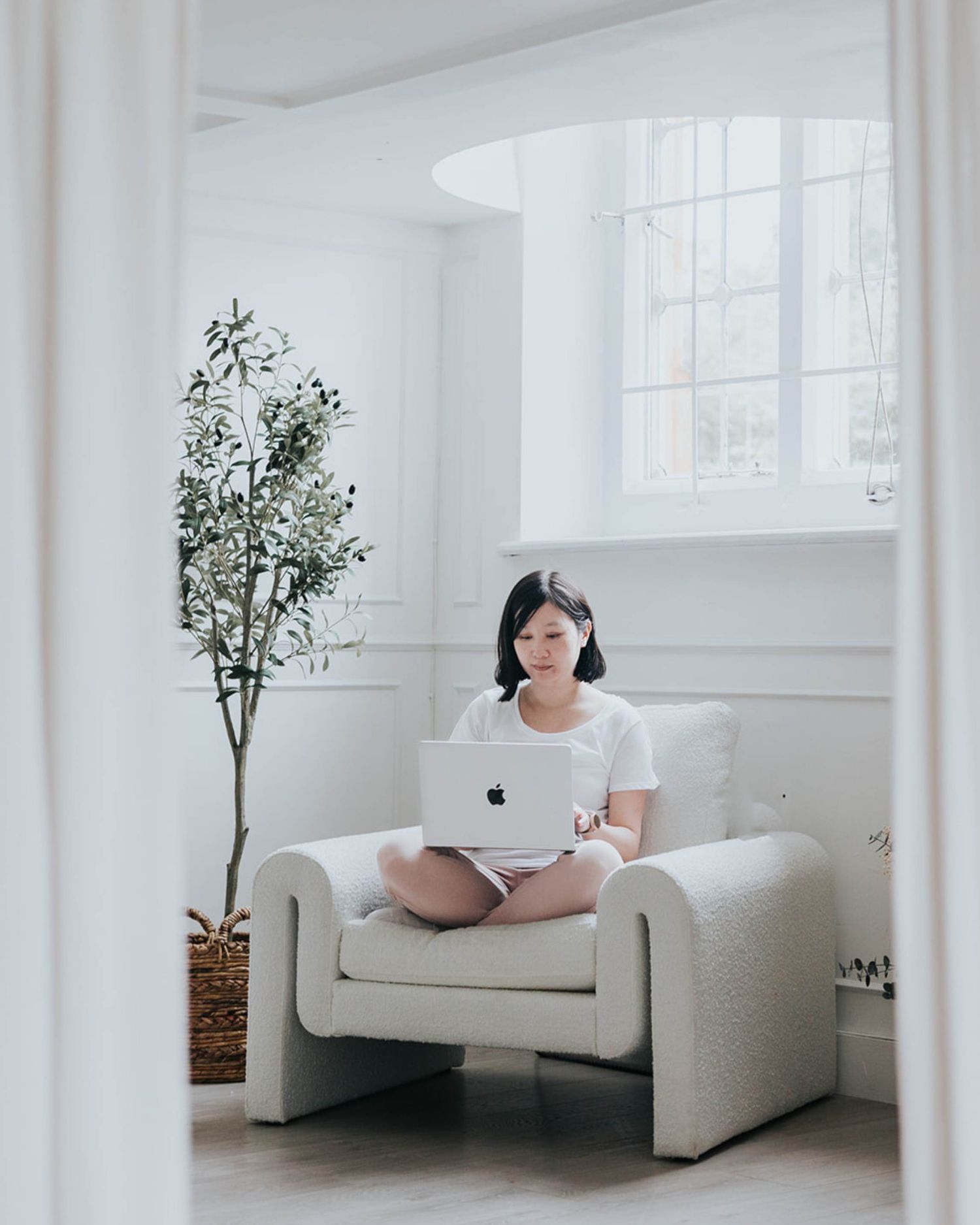 woman sat on sofa working on a laptop