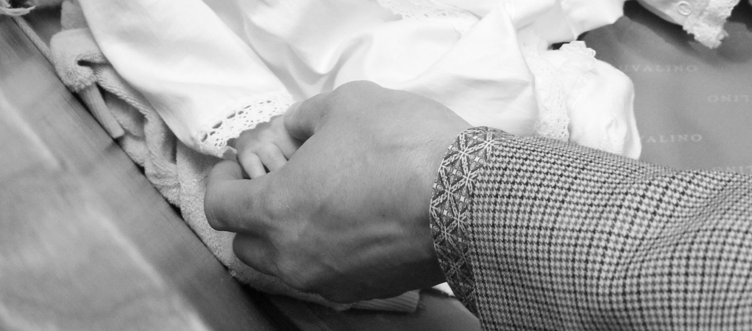 Close-up black and white image of hands during a baptismal ceremony.