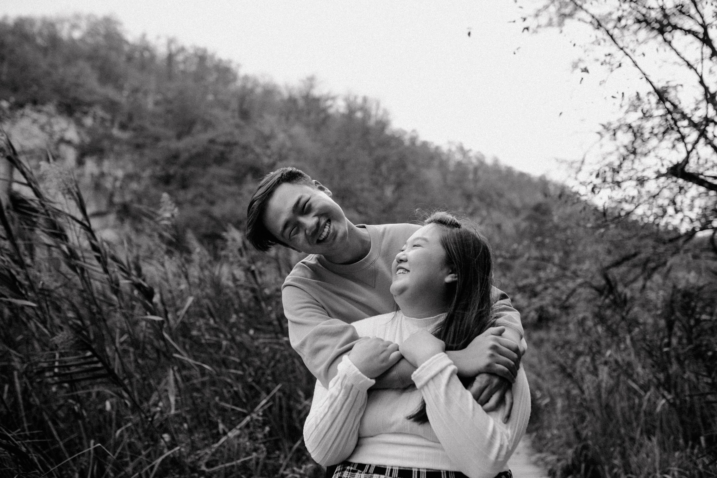 Black and white close-up of the couple hugging and laughing together, capturing a joyful and intimate moment.