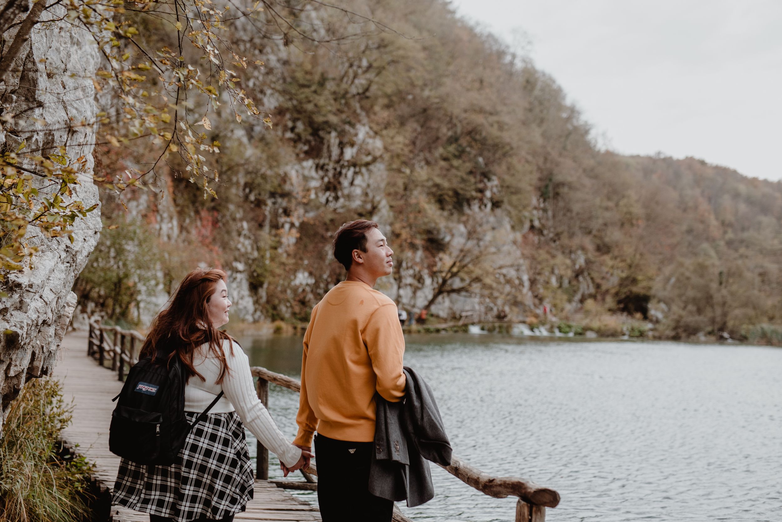 Couple exploring the scenic trails of Plitvice National Park during a vacation photoshoot.