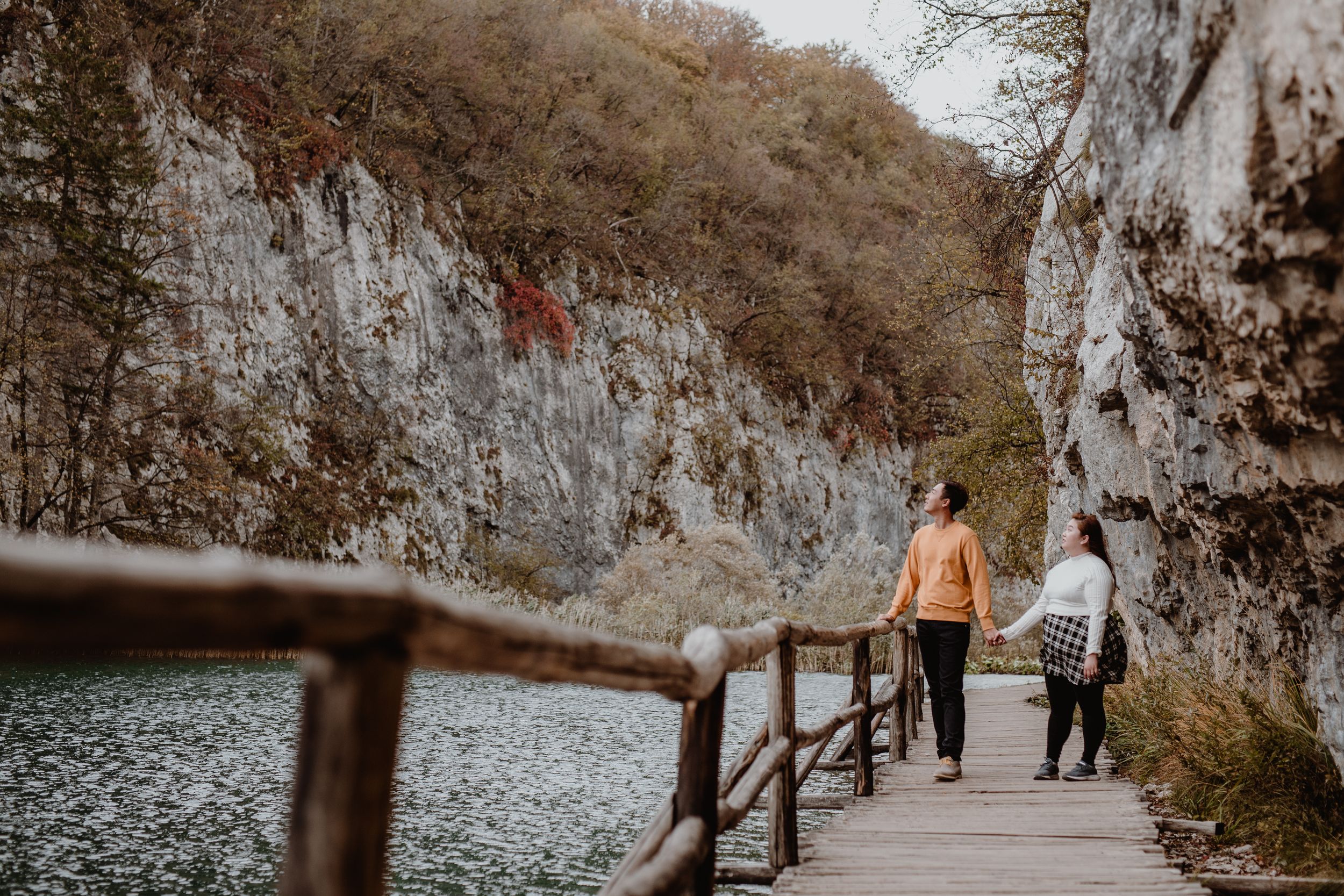 Couple strolling through the picturesque Plitvice National Park, surrounded by the natural beauty of the landscape.