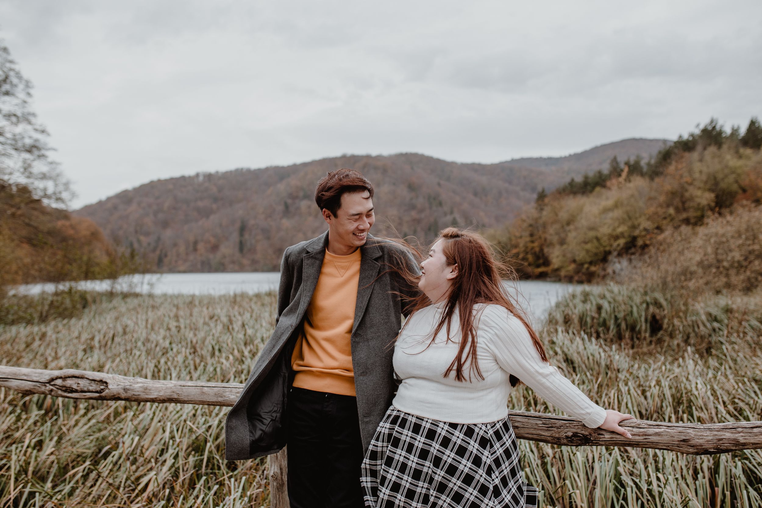 Couple standing and looking at each other,smiling and laughing during their vacation photoshoot at Plitvice in Croatia.