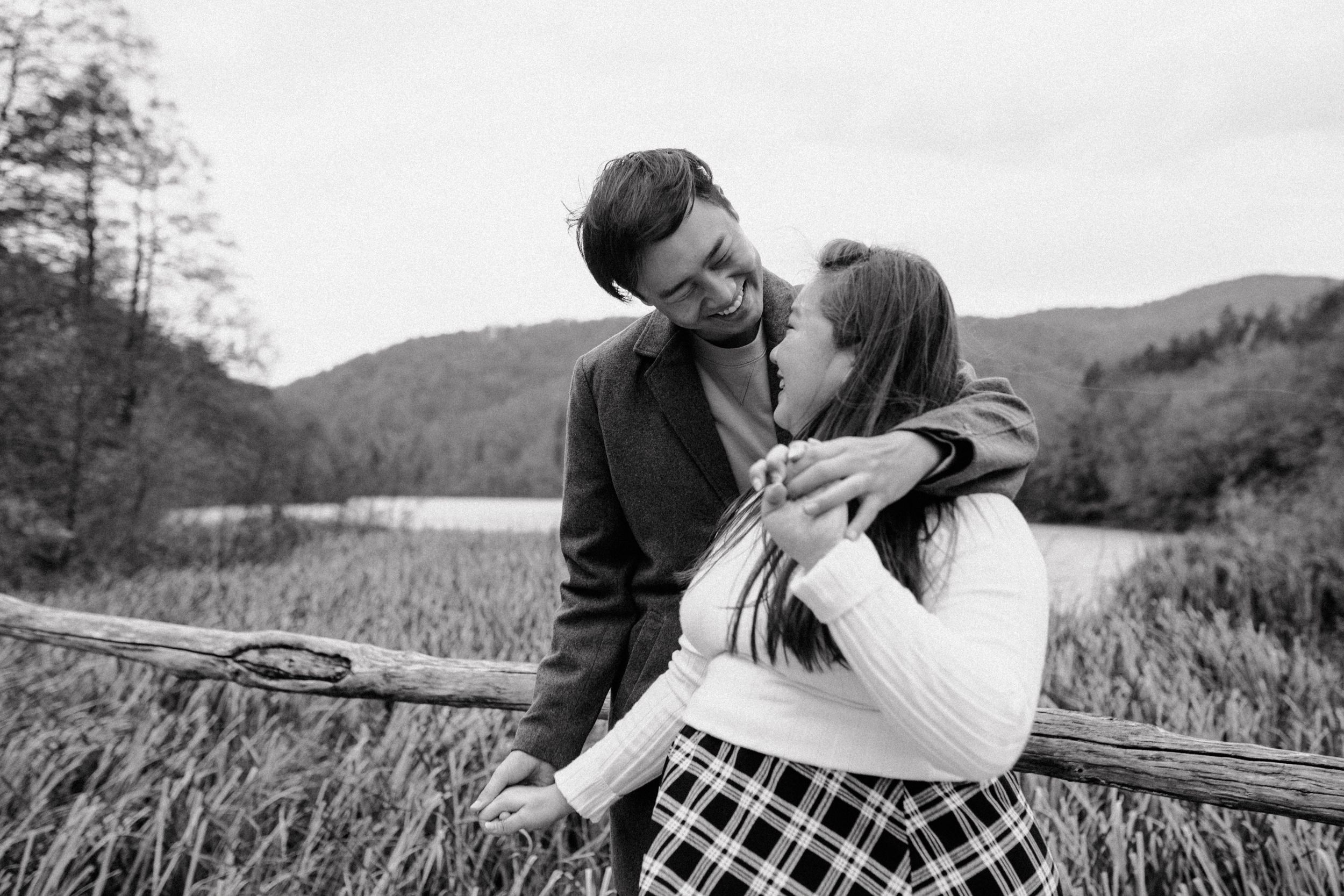 Black and white photo of the couple hugging and laughing together, capturing their joyful moment during the photoshoot.