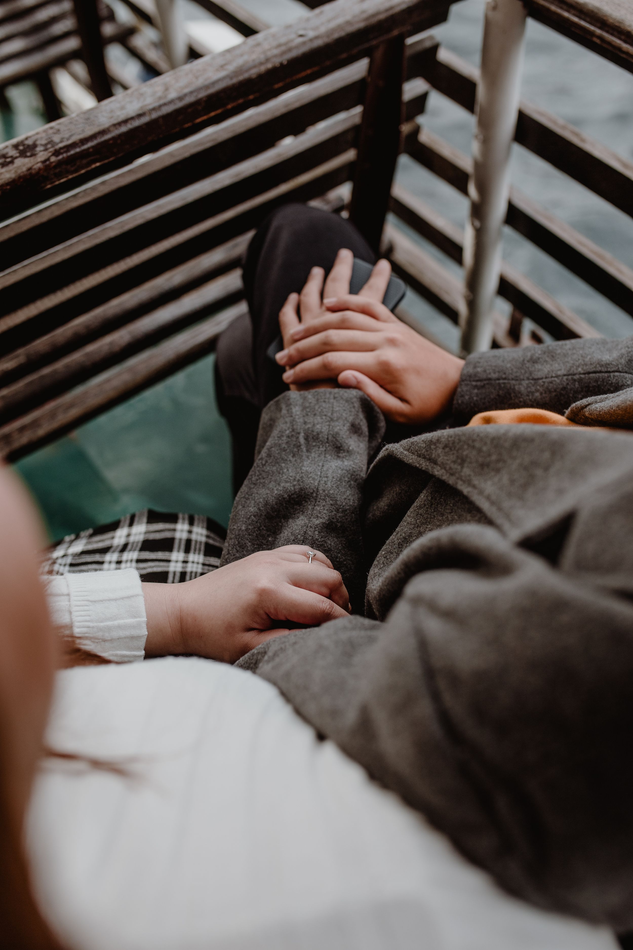 Close up photo of her hand resting gently on his arm as they enjoy their time at Plitvice National Park.