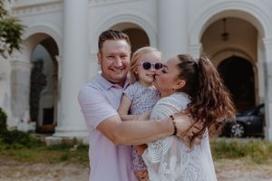 Parents hugging their child and smiling, capturing an authentic family moment in Upper Town, Zagreb