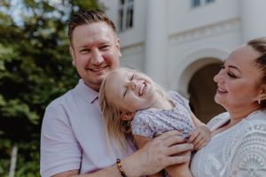 Close-up of a little girl laughing heartily, capturing a genuine moment of joy during a family vacation photoshoot.