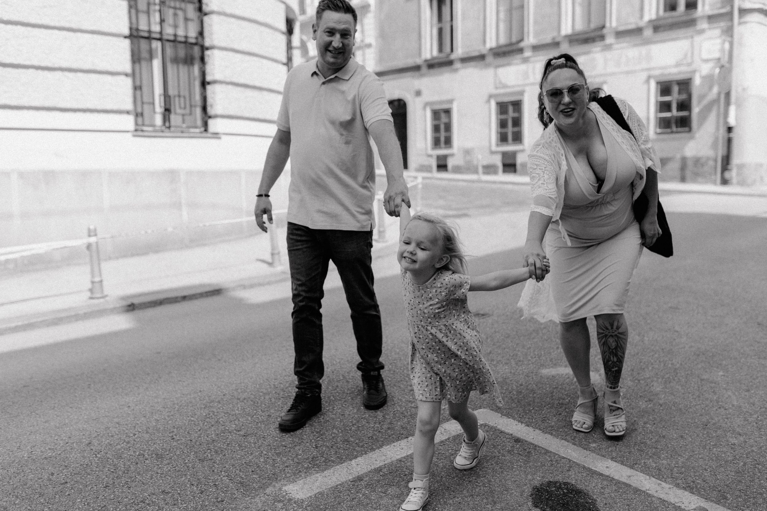 Family walking through Upper Town, Zagreb, with their child leading the way, holding hands and sharing a joyful moment