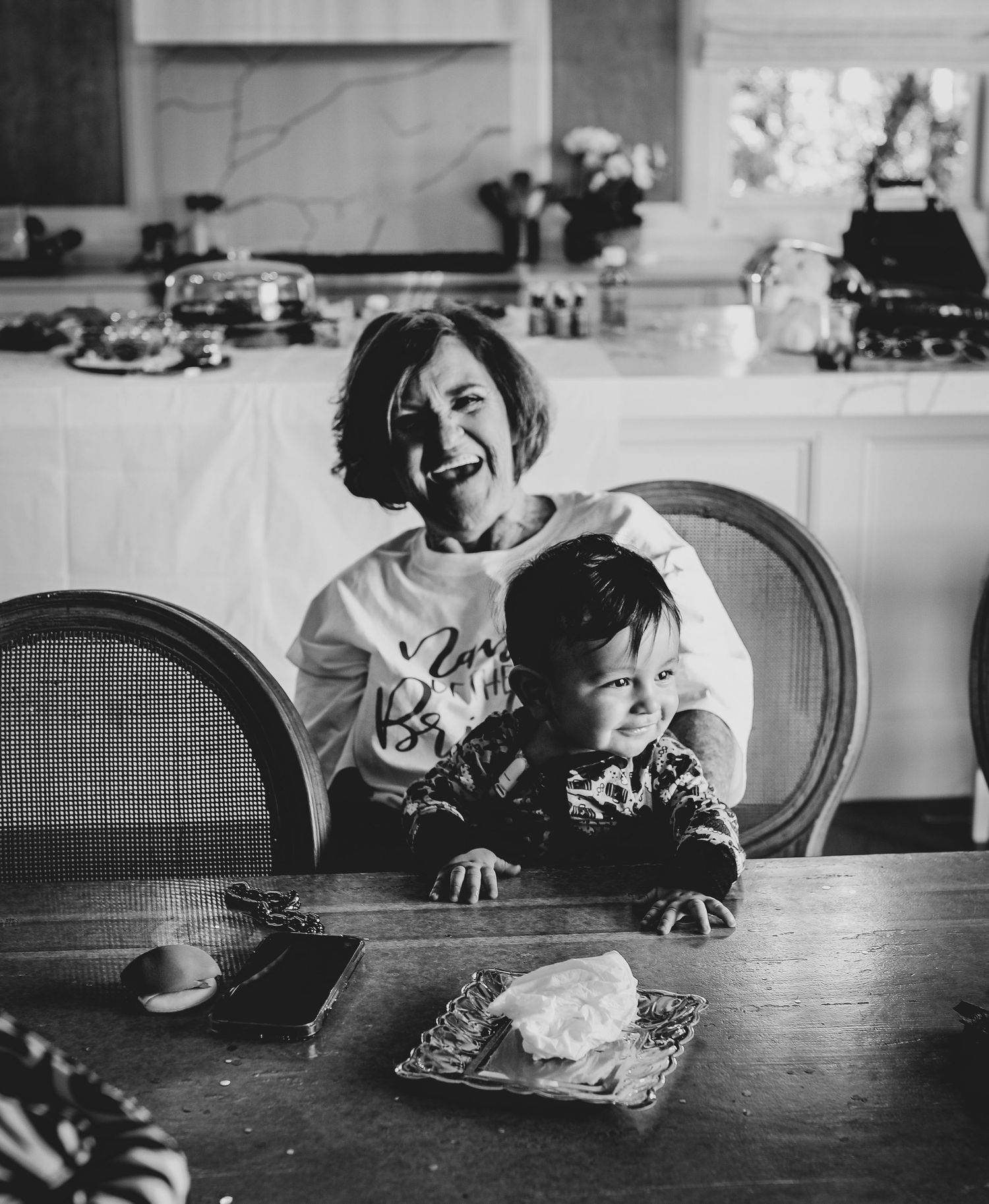 Candid black and white photo of joy shared at a dining table during a special moment.