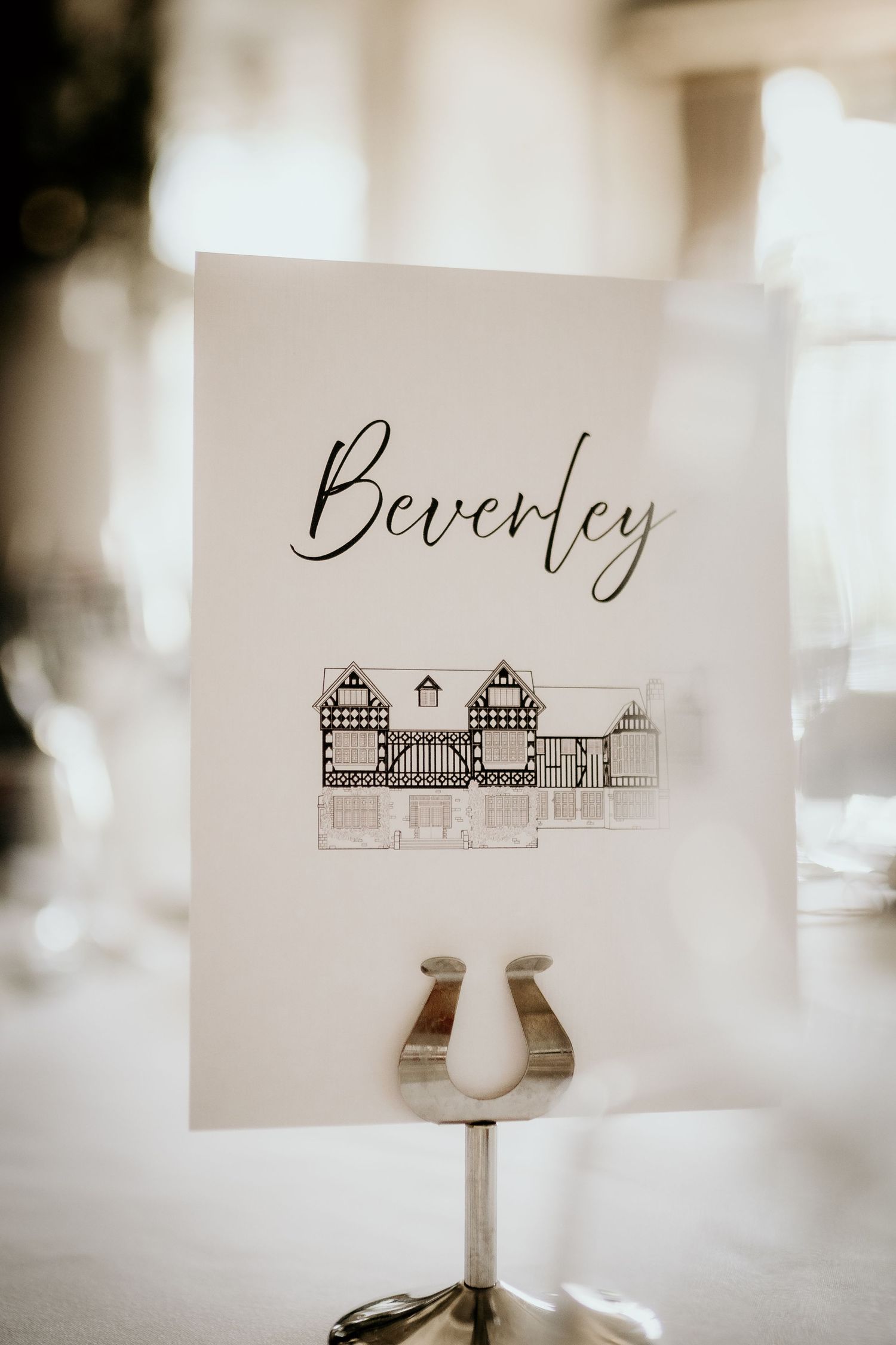Elegant wedding table place cards feature delicate architectural sketches of buildings in black ink on cream paper.