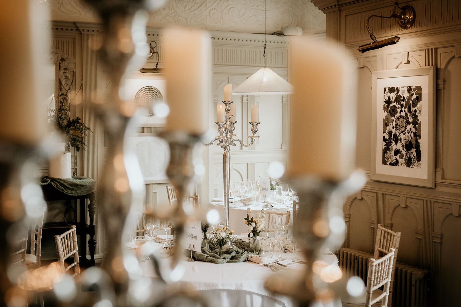An elegant wedding reception venue with crystal chandeliers and decorated dining tables set for a celebration.