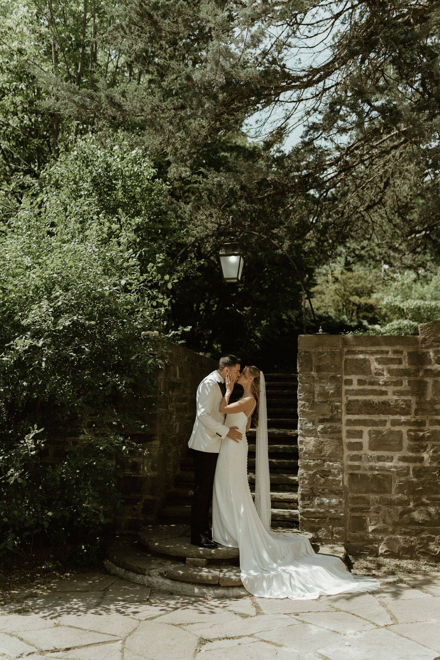 A romantic wedding photography sequence shows an intimate dip pose against a rustic stone wall backdrop in a garden setting.