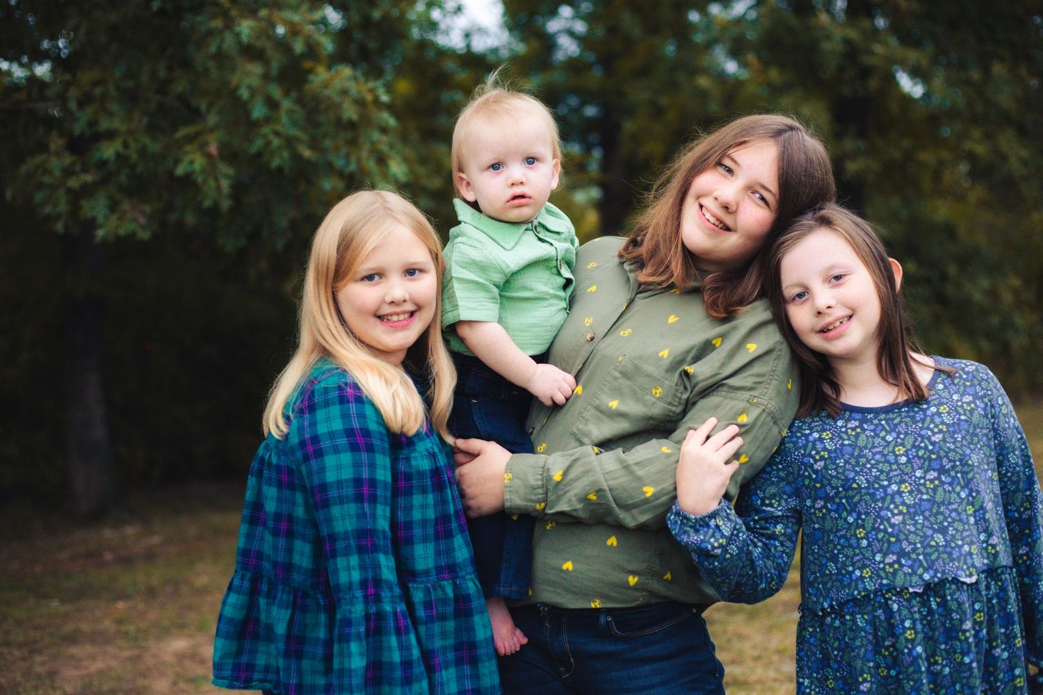 Four siblings smiling at camera at outdoor session in Yukon